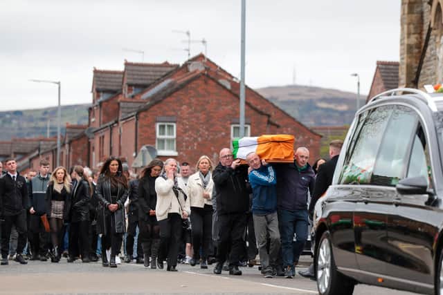 Family and friends gather for the funeral of Gerard 'Hucker' Moyna in west Belfast as his coffin makes its way to St Paul's for requiem mass today; a video purporting to show shots fired over his coffin the night before is online