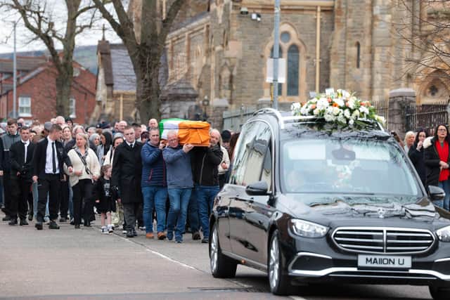 Family and friends gather for the funeral of Gerard 'Hucker' Moyna in west Belfast as his coffin makes it way to St. Paul's for Requiem Mass