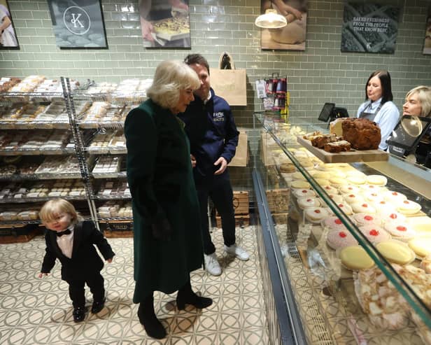 Queen Camilla meets the owner of Knotts Bakery, William Corrie with his son Fitz (left) and staff during a visit to Lisburn Road in Belfast