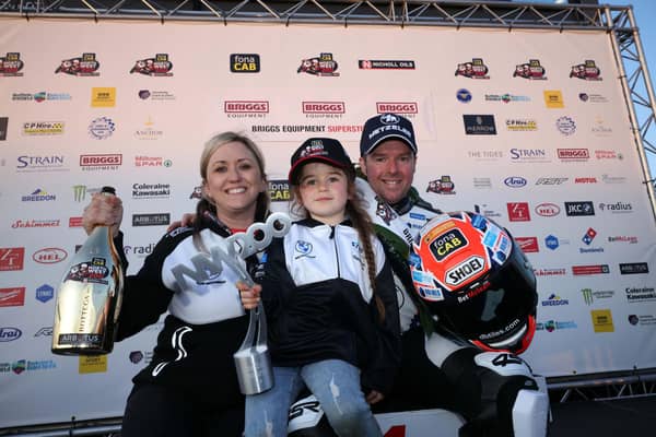 Alastair Seeley celebrates his victory in the opening Superstock race at the 2023 North West 200 with wife Danni and daughter Olivia-Grace