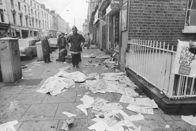 Firemen on Talbot Street, Dublin, use newspapers from a wrecked newspaper stand to cover a dead body after three car bombs exploded simultaneously in the city, 17th May 1974. The UVF later claimed responsibility for the attacks. (Photo by Keystone/Hulton Archive/Getty Images)