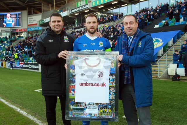 Linfield legend Jamie Mulgrew is presented with a shirt to mark his 700th appearance in the game against Dungannon Swifts.