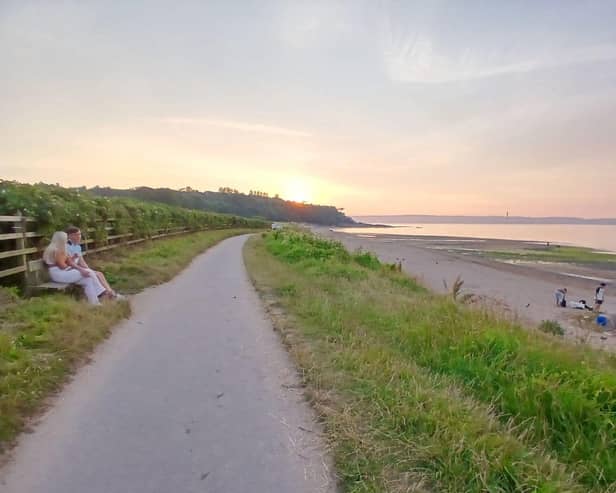 People enjoy the last of the sunshine at Crawfordsburn beach at 9.30pm on Thursday July 16 2026, a day which saw temperatures in parts of Northern Ireland reach 29 Celsius. The beach, on Belfast Lough, had been packed with people earlier, as was the nearby beach at Helen's Bay. Pic Ben Lowry