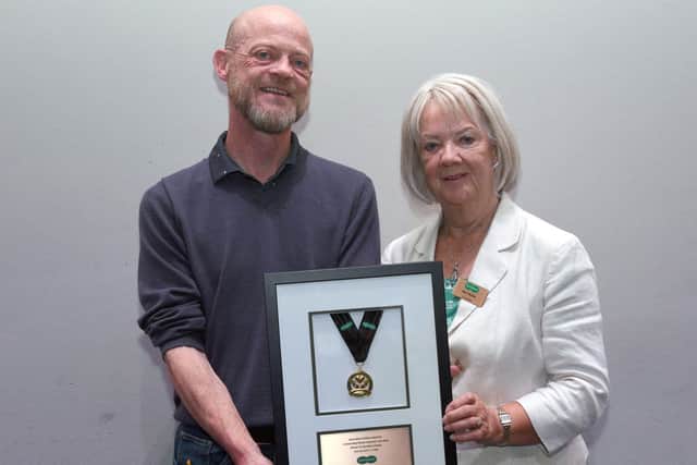 Dame Mary Perkins presenting store owner Brian O’Kane with the Dame Mary Perkins Medal for Outstanding Customer Care. Credit: Rob Lacey Photographer