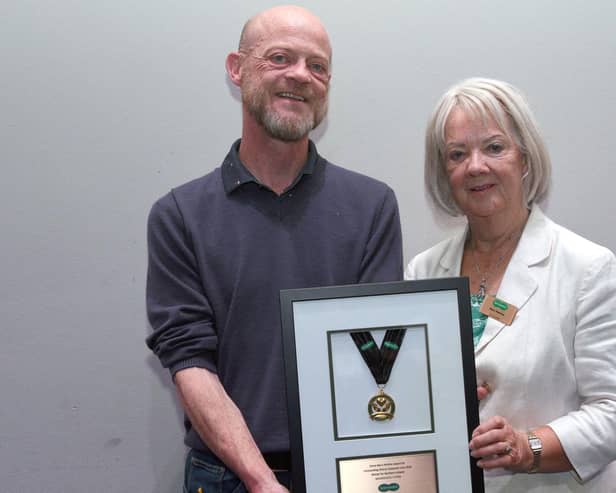 Dame Mary Perkins presenting store owner Brian O’Kane with the Dame Mary Perkins Medal for Outstanding Customer Care. Credit: Rob Lacey Photographer