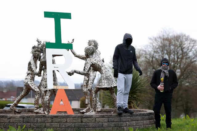 Two young men, one carrying a petrol bomb, stand next to an IRA sign in the Creggan area of Londonderry, as a Easter Monday parade commemorating the anniversary of the Easter Rising Rebellion of 1916 takes place. Picture date: Monday April 1, 2024. PA Photo. See PA story ULSTER Parade. Photo credit should read: Liam McBurney/PA Wire