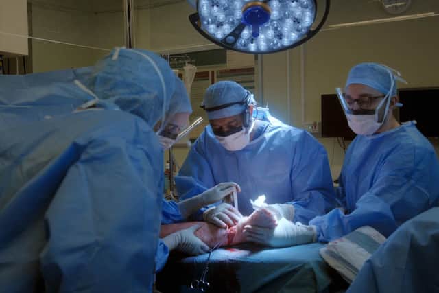 Surgeons performing operation on injured leg