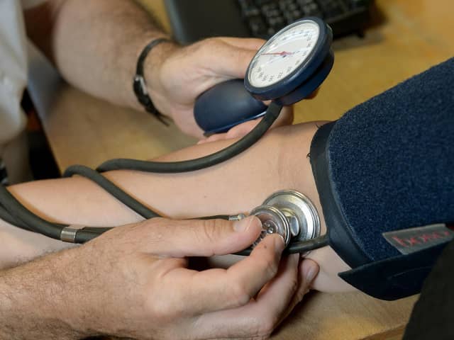 A doctor checking a patient's blood pressure. Photo: PA/Wire