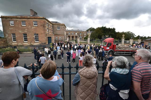 Members of the public gather for the gun salute in honour of Her Majesty the Queen at Hillsborough castle