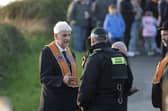 Nigel Dawson, Portadown District Master, speaks to a police officer as the orange men gather at Drumcree Church on Sunday