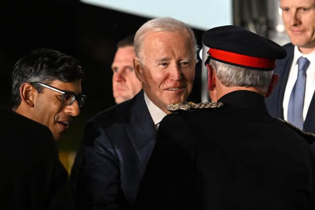 A third photo showing US President Joe Biden as he is greeted by Britain's Prime Minster Rishi Sunak after disembarking from Air Force One upon arrival at Belfast International Airport on April 11, 2023.