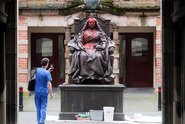 A member of Royal Victoria Hospital's medical staff photographs damage committed on the facility's grounds. Photo: Jonathan Porter/PressEye