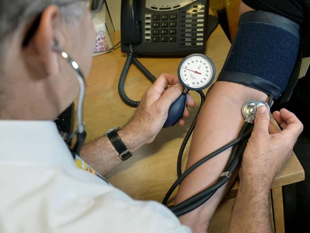 A doctor examines a patient; The decision by the Stormont Department of Health to cut GP funding by almost 7% in real terms is "astonishing", the BMA has said.