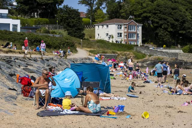 People enjoying the sun at Helen's Bay beach in County Down. The bank holiday weekend is expected to see some welcome warm weather across NI.