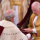 Lord Carrington presents spurs to King Charles during the coronation ceremony. The spurs symbolise knighthood and chivalry