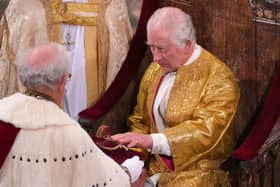 Lord Carrington presents spurs to King Charles during the coronation ceremony. The spurs symbolise knighthood and chivalry