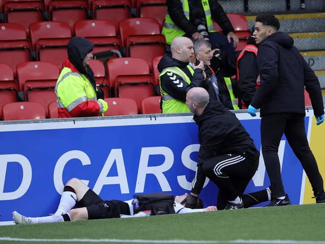 Glentoran's Bobby Burns receives treatment after colliding with an advertising board at Seaview on Saturday. (Photo by David Maginnis/Pacemaker Press)
