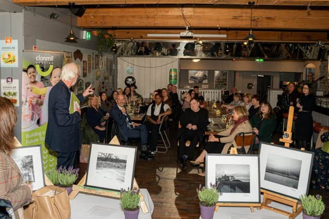 Guests and course participants at the photography exhibition listening to compere  Tim McGarry