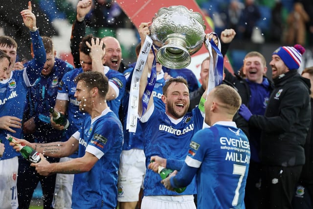 Linfield captain Jamie Mulgrew lifts the BetMcLean Cup after defeating Coleraine