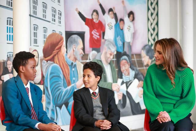 Queen Rania of Jordan (right) listening to Abdisalam Abdiaziz during her visit to the Conway Education Centre at Conway Mill in Belfast, during her visit to the One Young World Summit
