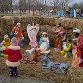 A mother and her child look at a Catholic Christian nativity scene on December 25, 2022 in Pokrovsk, Ukraine. Ukrainians celebrate Catholic Christmas on December 25 as the Orthodox Christmas on January 7 is considered a Russian tradition. (Photo by Pierre Crom/Getty Images)