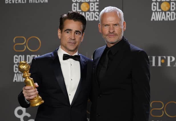 Colin Farrell, winner of the award for best performance by an actor in a motion picture, musical or comedy for "The Banshees of Inisherin," left, and Martin McDonagh, winner of the award for best screenplay, motion picture for "The Banshees of Inisherin," pose in the press room at the 80th annual Golden Globe Awards at the Beverly Hilton Hotel on Tuesday, Jan. 10, 2023, in Beverly Hills, Calif. (Photo by Chris Pizzello/Invision/AP)