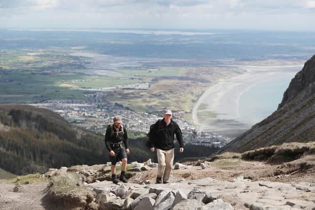 L-R National Trust Mountain rangers Theo Burke and James Fisher walk along the newly constructed 2 kilometers of hand laid stone path on Slieve Donard in Newcastle Co Down. Picture date: Friday May 21, 2021.