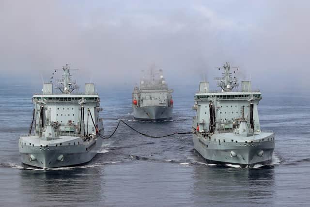 RFA Tidesurge, (left), refuelling RFA Tideforce (right), at sea followed by RFA Fort Victoria