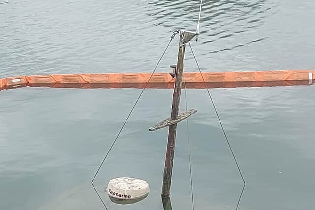 A close-up of the top of the mast, surrounded by the oil boom
