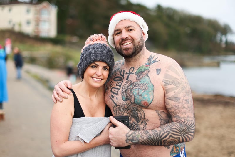 Ciaran May from Natural Resilience and Ciara Daly join swimmers from north Down take part in the annual Santa Splash at Helens Bay beach, County Down.