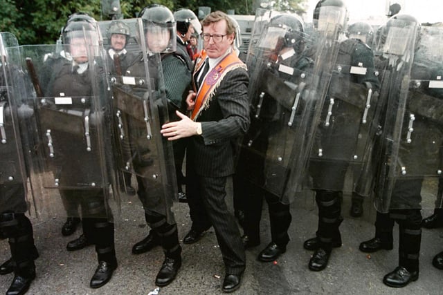 Ulster Unionist MP David Trimble squeezes through the RUC line after negotiations with senior RUC officiers to prevent the stand-off at Drumcree Parish Church after the RUC prevent the Orange Order parade marching through a nearby  nationist area. :-
