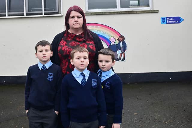 Parent Joyce Holmes with her children Daniel, Adam and Mathew Shields. The decision to close their school, Kingsmills Primary School, has left them devastated, she said. Pic Pacemaker