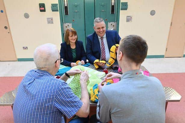 Governor of Maghaberry Prison, David Savage and Julie McConville, Assistant Director for Specialist Child Health and Disability with the Southern Health & Social Care Trust, review the crocheting work of the 'Stitch in Time Gang' (Image: Michael Cooper)