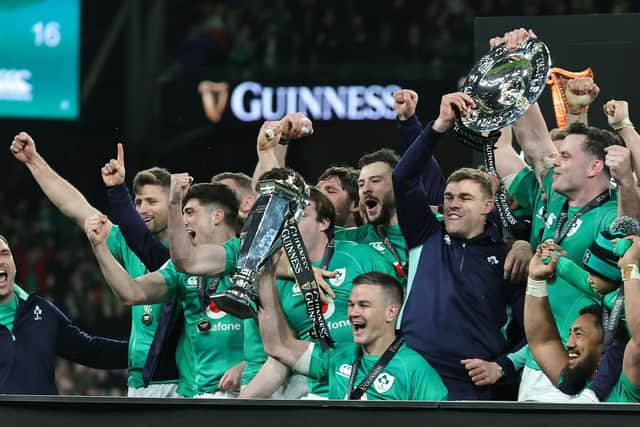Johnny Sexton, (C) the Ireland captain, holds the Six Nations trophy as Ireland celebrate their Grand Slam victory after victory over England at the Aviva Stadium in Dublin on Saturday.