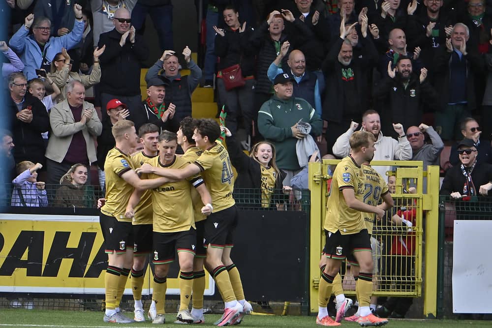 Jordan Jenkins is mobbed by his Glentoran team-mates after scoring the winner against Cliftonville at Solitude