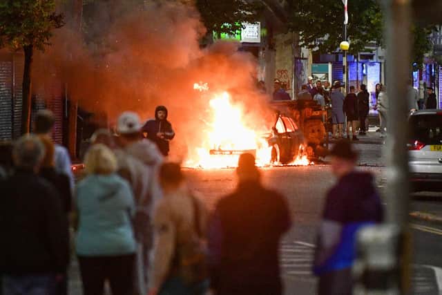 A car burns in Sandy Row amid anti-immigrant rioting