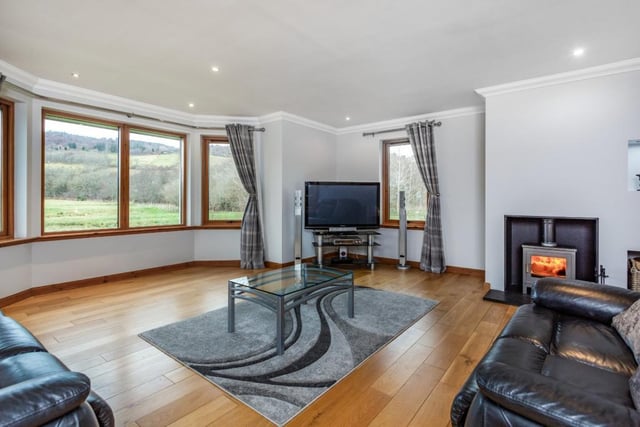 The sitting room has a feature front aspect bay window, wooden flooring and fireplace with wood burning stove.