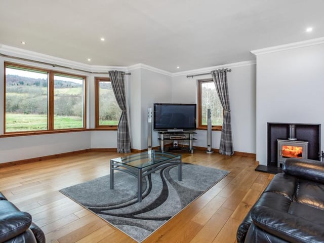 The sitting room has a feature front aspect bay window, wooden flooring and fireplace with wood burning stove.