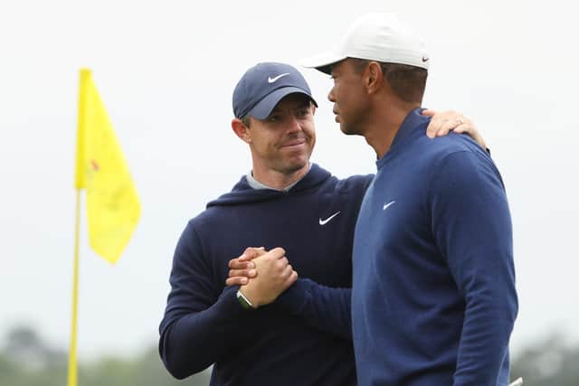 Rory McIlroy shakes hands with Tiger Woods after a practice round ahead of The Masters