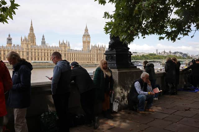 LONDON, ENGLAND - SEPTEMBER 14: Well-wishers stand in the queue for the Lying-in State of Queen Elizabeth II by the river Thames across from the houses of Parliament  on September 14, 2022 in London, England. Queen Elizabeth II's coffin is taken in procession on a Gun Carriage of The King's Troop Royal Horse Artillery from Buckingham Palace to Westminster Hall where she will lay in state until the early morning of her funeral. Queen Elizabeth II died at Balmoral Castle in Scotland on September 8, 2022, and is succeeded by her eldest son, King Charles III.  (Photo by Dan Kitwood/Getty Images)