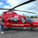 Hannah Williamson from Dungannon Silver Band alongside the air ambulance. The band will play a short concert on the top of Northern Ireland's highest peak, Slieve Donard, in a bid to raise funds for Air Ambulance NI