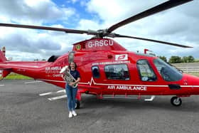 Hannah Williamson from Dungannon Silver Band alongside the air ambulance. The band will play a short concert on the top of Northern Ireland's highest peak, Slieve Donard, in a bid to raise funds for Air Ambulance NI