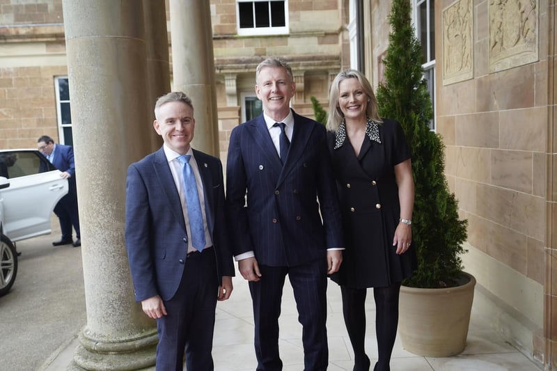 Patrick Kielty is welcomed by Laura McCorry of Hillsborough Castle and Ryan Feeney (left) of Queen's University at a Gala dinner to recognise Mo Mowlam's contribution to the peace process and to mark the 25th anniversary of the Good Friday Agreement at Hillsborough Castle in Northern Ireland. Picture date: Sunday April 16, 2023.