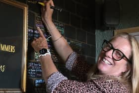 Grace McLaughlin, a 54-year-old mother of three from Bangor, adds her name to the 'wall of champions' in Pier 36, Donaghadee, after completing swimming’s Irish triple crown. Photo: Angel Comms/PA Wire