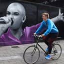 A cyclist passes a mural of Sinead O'Connor by artist Emmalene Blake on Dame Lane in Dublin. Pic: Damien Eagers/PA Wire