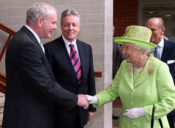 Britain's Queen Elizabeth II (2nd R) shakes hands with Northern Ireland Deputy First Minister Martin McGuinness (L) watched by First Minister Peter Robinson (2nd L) and Prince Philip (R) at the Lyric Theatre in Belfast, in 2012. If the former IRA commander, the late Mr McGuinness, could shake hands with the late Queen, Sinn Fein will milk the coronation politically (Photo by PAUL FAITH/AFP via Getty Images)