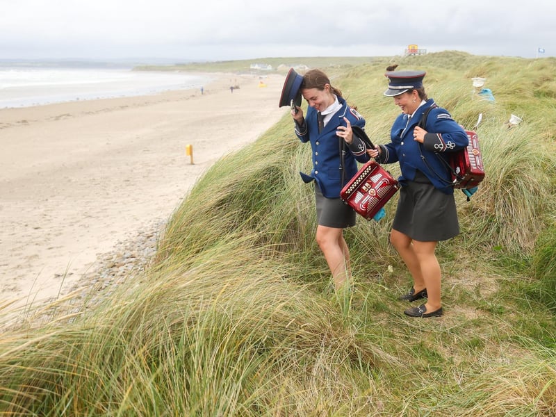 Bands women make their way through the dunes to the beach