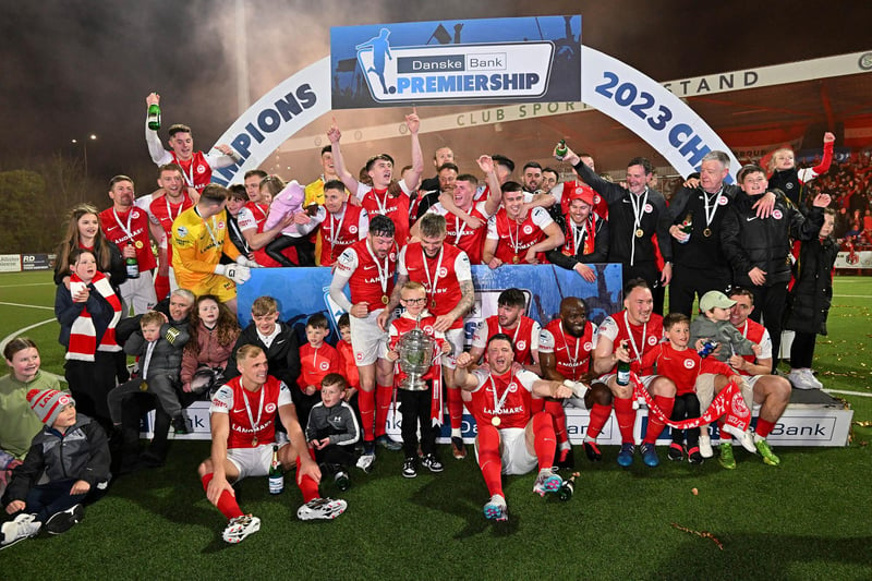 Larne players and staff celebrate winning the Premiership title