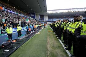 Police officers and stewards form a line to separate the fans on Sunday at Ibrox in the Scottish Cup tie between Rangers and Celtic. (Photo by Steve Welsh/PA)