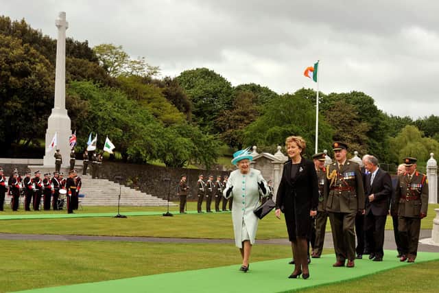 Queen Elizabeth II and the President of the Irish Republic Mary McAleese walk through the ground of the Irish War Memorial Garden in 2011. The walking tour takes in the serene gardens and notes the huge cross on the left, which the IRA tried to blow up twice. Photo: John Stillwell/PA Wire